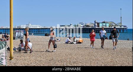 Brighton UK 15. Mai 2020 - Menschen unter 30 Jahren versammeln sich am Strand von Brighton und am Meer an einem sonnigen Tag an der Südküste. Allerdings hoffen die Abgeordneten von Brighton, dass die Massen an diesem Wochenende nicht an der Küste absteigen, nachdem die Regierungen die Beschränkungen der Lockdown in England während der COVID-19-Pandemie leicht gelockert hatten. Quelle: Simon Dack / Alamy Live News Stockfoto