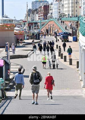 Brighton UK 15. Mai 2020 - Menschen versammeln sich an der Küste von Brighton an einem sonnigen Tag an der Südküste. Allerdings hoffen die Abgeordneten von Brighton, dass die Massen an diesem Wochenende nicht an der Küste absteigen, nachdem die Regierungen die Beschränkungen der Lockdown in England während der COVID-19-Pandemie leicht gelockert hatten. Quelle: Simon Dack / Alamy Live News Stockfoto