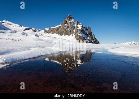 Winterlandschaft mit einem schönen schneebedeckten Berg in einem See reflektiert Stockfoto
