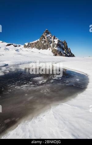 Winterlandschaft mit einem schönen schneebedeckten Berg in einem See reflektiert Stockfoto