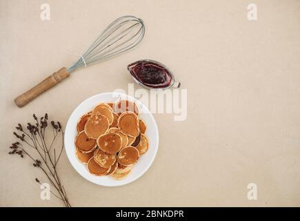 Trendige Pfannkuchen-Frühstücksflocken. Winzig gebackene Pfannkuchen mit Cranberry Marmelade. Frühstück. Ansicht von oben. Stockfoto