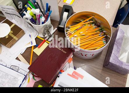 Austin Texas, USA, Januar 2013: Ein Eimer voller Bleistifte sitzt neben einem christlichen Gebetsführer auf dem Schreibtisch eines Lehrers in einem Klassenzimmer der zweiten Klasse der katholischen Privatschule. ©Bob Daemmrich Stockfoto