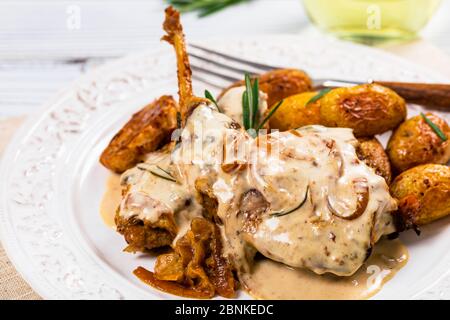 Gebratenes Kaninchenfleisch mit Rosmarin in Sour Cream Sauce und Kartoffel Stockfoto