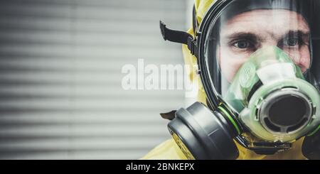 Nahaufnahme Des Kaukasischen Mannes Stehend Beobachtung Und Tragen Gefahrstoffanzug Und Gasmaske. Stockfoto