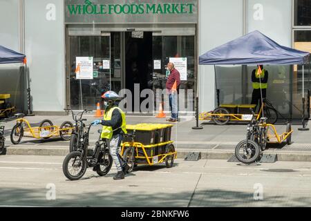 Whole Foods Market setzt Carla Cargo Anhänger mit E-Bike für die Lebensmittellieferung in Midtown Manhattan während der COVID-19 Pandemie in New York City, USA ein Stockfoto