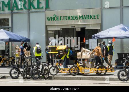 Whole Foods Market setzt Carla Cargo Anhänger mit E-Bike für die Lebensmittellieferung in Midtown Manhattan während der COVID-19 Pandemie in New York City, USA ein Stockfoto