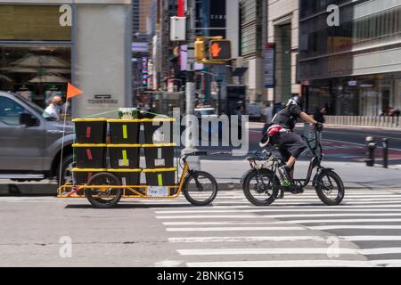 Whole Foods Market setzt Carla Cargo Anhänger mit E-Bike für die Lebensmittellieferung in Midtown Manhattan während der COVID-19 Pandemie in New York City, USA ein Stockfoto