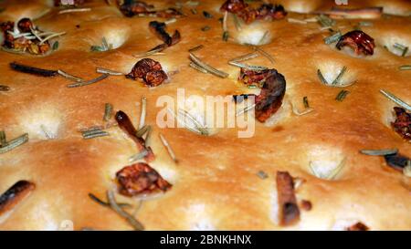 FOCACCIA BROT IN EINEM BACKBLECH MIT SONNENGETROCKNETEN TOMATEN MIT ROSMARIN, KNOBLAUCH, OLIVENÖL ÜBERBACKEN Stockfoto