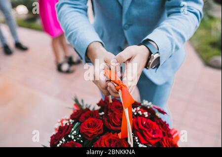 Bouquet aus nächster Nähe, das Bouquet besteht aus roten Rosen. Der Mann hält einen Strauß Stockfoto