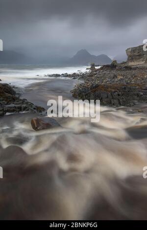 River Abfluss ins Meer läuft im Elgol mit Blick auf die Cuillin, Isle of Skye, Innere Hebriden, Schottland, Großbritannien, Oktober 2013. Stockfoto