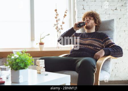 Porträt von Millennial Junge mit Retro-Stil, Treffen Dinge aus der Vergangenheit und Spaß haben. Generation of Digital Devices untersucht vergangene Unterhaltung der 90er Jahre. 90-s trendy Look, Jugend. Cola trinken. Stockfoto