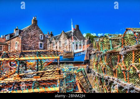 Town of Crail, Schottland. Künstlerische Ansicht der Crail-Kais mit Hummertöpfen im Vordergrund und Hafenresidenzen im Hintergrund. Stockfoto