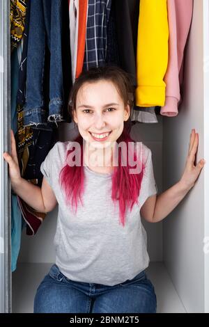 Junges Mädchen kommt glücklich aus Schrank und lächelt Stockfoto