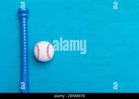 Blauer Baseballschläger und Ball auf blauem Holzhintergrund Stockfoto