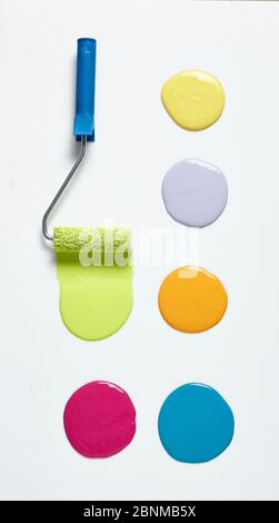 Malerrolle, Farbwalze mit bunten Farbballen auf Weiß, Zusatzbild zum Thema DIY Wall Design 01, Schritt-für-Schritt-Selbstbau, vertikale farbige Farbstreifen im unteren Wandbereich Stockfoto