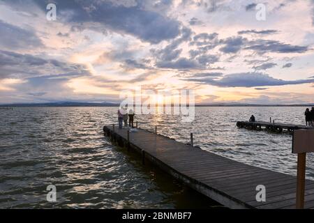 Landschaft eines Sees mit Sturmwolken, bewegende Gewässer Schilf im Wasser, bläuliche Töne, Pier, Stockfoto