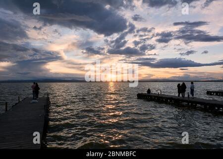 Landschaft eines Sees mit Sturmwolken, bewegende Gewässer Schilf im Wasser, bläuliche Töne, Pier, Stockfoto