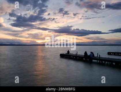 Landschaft eines Sees mit Sturmwolken, bewegenden Wasser Schilf im Wasser, bläuliche Töne, Pier, lange Exposition, Seide-Effekt Stockfoto