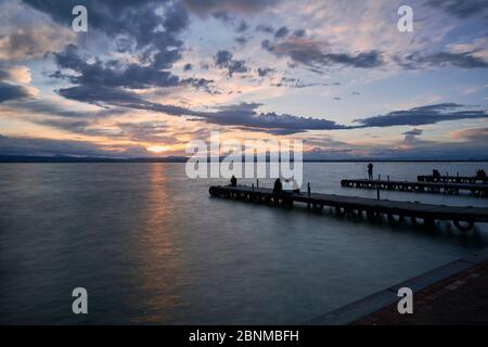 Landschaft eines Sees mit Sturmwolken, bewegenden Wasser Schilf im Wasser, bläuliche Töne, Pier, lange Exposition, Seide-Effekt Stockfoto