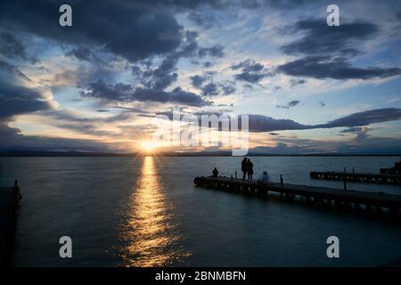 Landschaft eines Sees mit Sturmwolken, bewegenden Wasser Schilf im Wasser, bläuliche Töne, Pier, lange Exposition, Seide-Effekt Stockfoto