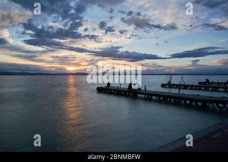 Landschaft eines Sees mit Sturmwolken, bewegenden Wasser Schilf im Wasser, bläuliche Töne, Pier, lange Exposition, Seide-Effekt Stockfoto