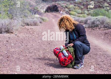 Sportliche Hündin mit Rucksack-Kontrollausrüstung während einer Trekking-Expedition - Outdoor-Sport-Aktivität Wandern und Wandern in der Natur - alternatives Reisekonzept mit Überlebenswerkzeugen Stockfoto