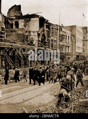 WWII - EIN gedrucktes Bild von 1941, das den Zweiten Weltkrieg zeigt, wie König George Southampton, England nach dem großen Bombenangriff vom 30. November 1940 besucht, während Truppen weiterhin die Straßen von Schutt und Asche räumen. Stockfoto