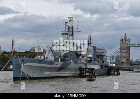 HMS Belfast ist ein historisches Kriegsschiff und Museum, das Geschichten vom Leben an Bord erforscht. Gelegen an der Themse, London, Großbritannien. Tower Bridge nach hinten Stockfoto