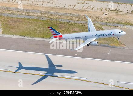 American Airlines Airbus A321 Abfahrt vom Flughafen Los Angeles LAX, USA. Flugzeug Schatten in Flughafen Start- und Landebahn. Luftaufnahme des Flugzeugs. Luft zu Luft. Stockfoto
