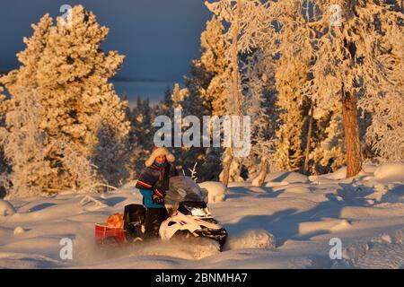 Nils-Torbjorn Nutti, Besitzer und Betreiber von Nutti Sami Siida, auf einer Motorschlittenfahrt in die Wildnis, Jukkasjarvi, Lappland, Laponia, Norrbotten County, Stockfoto