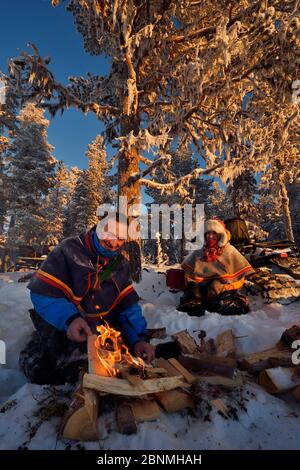 Nils-Torbjorn Nutti, Eigentümer und Betreiber bei Nutti Sami Siida, und Klara Enbom-Burreau auf einer Motorschlittenfahrt in die Wildnis, Jukkasjarvi, Lappland, Lappland, Lap Stockfoto