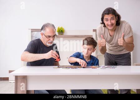 Drei Generationen von Familie spielen Puzzle Stockfoto