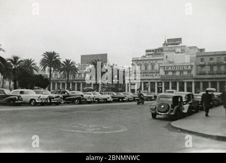 Vintage-Foto, Blick auf die Geschäfte in Santos, São Paulo State, Brasilien am 12. Juli 1955. Es sind Schilder für Cinzano, Caodusa, Grant's Scotch Whisky und mehr zu sehen. Von einem Passagier, der von einem Kreuzfahrtschiff entbellen kann. QUELLE: ORIGINALFOTO Stockfoto