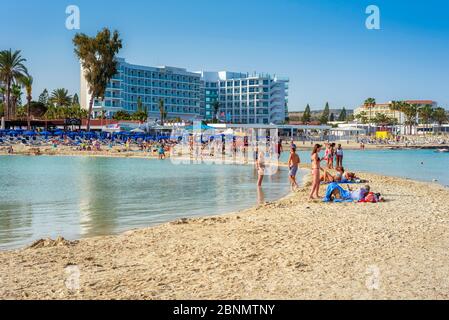 AYIA NAPA, ZYPERN - 21. April 2018: Touristenmassen, die sich am Strand von Nissi entspannen Stockfoto