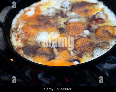 Rührei in einer Pfanne auf einem Feuer gebraten Stockfoto