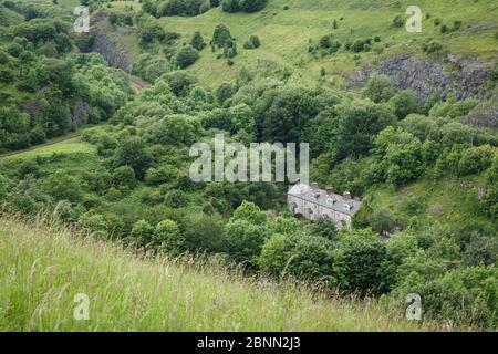 Bahnhof Cottages, Chee Dale, Nationalpark Peak District, Derbyshire, UK. Steinbruch Kalkstein rockfaces kann entlang der Kante über gesehen werden. Stockfoto