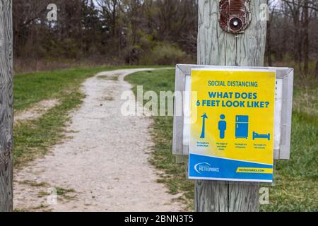 Washington Township, Michigan - EIN Schild an einem Wegweiser in Stony Creek Metropark erinnert Wanderer daran, die richtige soziale Distanz zu bleiben während der c Stockfoto