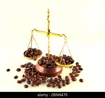 Kaffee Thema mit Messingschuppen Stillleben auf weißem Hintergrund. Kaffeebohnen auf der Waage. Stockfoto