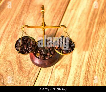 Kaffee Thema mit Messingschuppen Stillleben auf einem Holztisch. Kaffeebohnen auf der Waage. Stockfoto