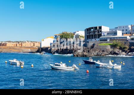 Blick vom malerischen Fischerhafen auf Restaurants, Häuser und einen kleinen Strand, bekannt als Playa Grande in Los Abrigos, Teneriffa, Spanien Stockfoto