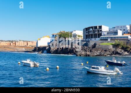 Blick vom malerischen Fischerhafen auf Restaurants, Häuser und einen kleinen Strand, bekannt als Playa Grande in Los Abrigos, Teneriffa, Spanien Stockfoto