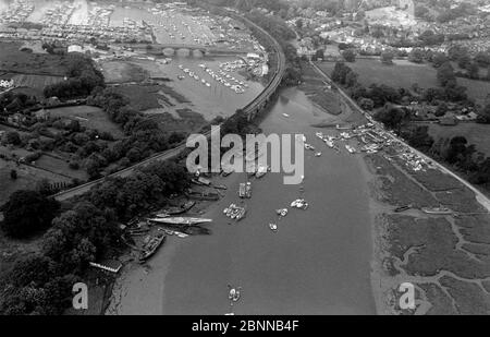 AJAXNETPHOTO. 1979. BURSLEDON, ENGLAND. - YACHTING MEKKA - AUS DER VOGELPERSPEKTIVE AUF DEN BERÜHMTEN HAMBLE RIVER, DER SICH NACH SÜDWESTEN IN RICHTUNG SOUTHAMPTON WATER UND SOLENT SCHLÄNGELT. IM VORDERGRUND BEFINDET SICH DIE BURSLEDON RAILWAY RIVER, DIE DAS VIADUKT ÜBERQUERT, MIT DER A27 ROAD BRIDGE IN DER MITTE; DIE RIVERSIDE BOOTSWERFT ERSTRECKT SICH VON LINKS NACH RECHTS IN DIE VORDER; MOODY'S SWANICK MARINA OBEN LINKS. FOTO: JONATHAN EASTLAND/AJAX REF:1979 4055 Stockfoto