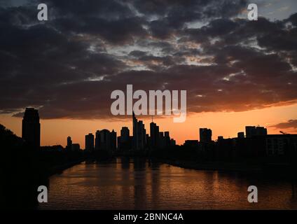 15. Mai 2020, Hessen, Frankfurt am Main: Die Sonne geht am Abend hinter den Hochhäusern der Bankenstadt unter. Foto: Arne Dedert/dpa Stockfoto