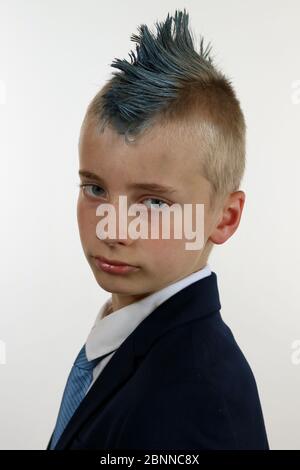 Porträt eines jungen Mannes, der einen Business-Anzug trägt und einen blauen Mohawk sieht ernst aus Stockfoto