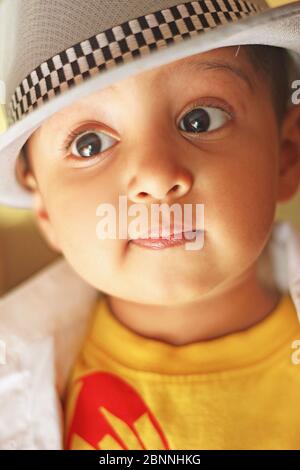Porträt eines süßen südasiatischen Jungen trägt ein Hemd und Fedora-Hut. Studioaufnahme Stockfoto