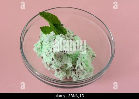Minze Chocolate Chip Eis in Glas Dessertschüssel mit frischen Minzblättern garnieren Stockfoto