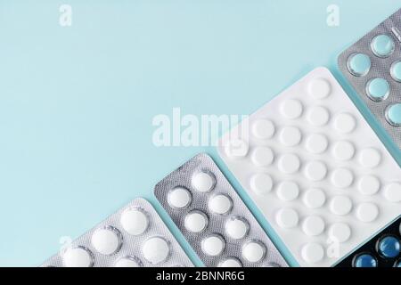 Tabletten in Blister, Pillen auf blauem Hintergrund. Apotheke, Gesundheitskonzept. Behandlung mit dem Coronavirus. Drogeriekonzept. Tablettenüberdosis. Stockfoto