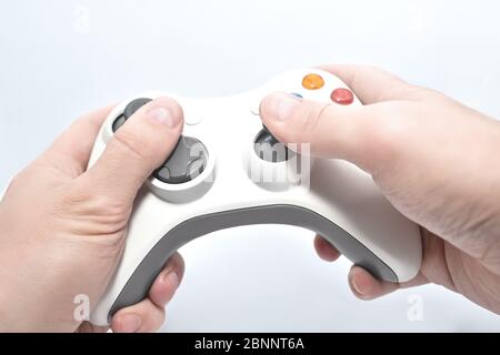 Joystick Gamepad in der Hand des Spieler auf weißem Hintergrund Stockfoto