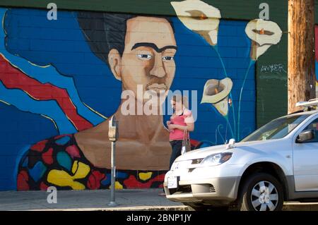 Eine Frau geht an einem Wandgemälde vorbei, das die mexikanische Künstlerin Frida Kahlo in den Straßen von Los Angeles, CA, zeigt Stockfoto