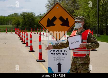 Iowa National Guard Spc. Ben Falkers leitet den Verkehr an einem COVID-19, Coronavirus Drive-Thru-Teststandort am Kirkwood Community College, 7. Mai 2020 in Cedar Rapids, Iowa. Stockfoto